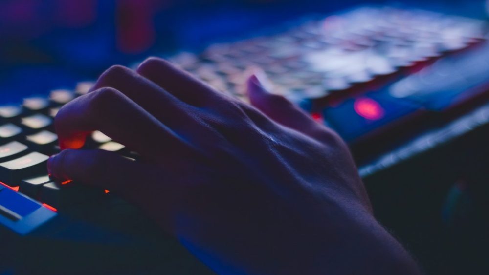 a hand typing on the keyboard, dark theme