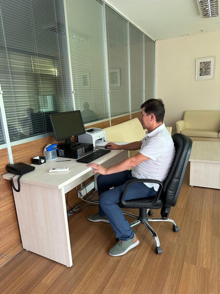 D Kaldiyarov working by the deskk in a room
