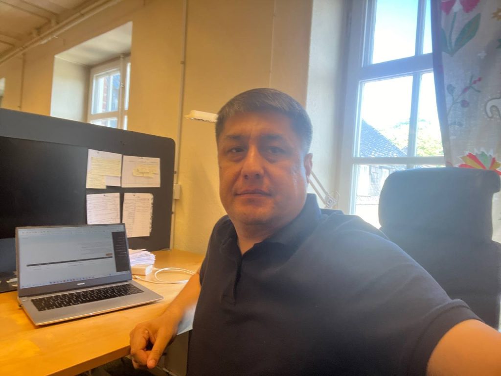 a selfie of Rakhmanov sitting by the desk